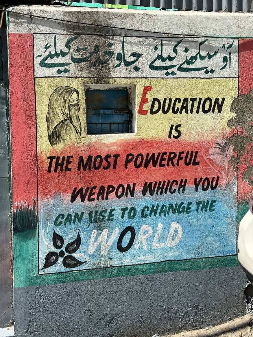 A colourful school wall mural reading: Education is the most powerful weapon which you can use to change the world.